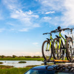 Three Bicycles On Roof Racks At The River Bank